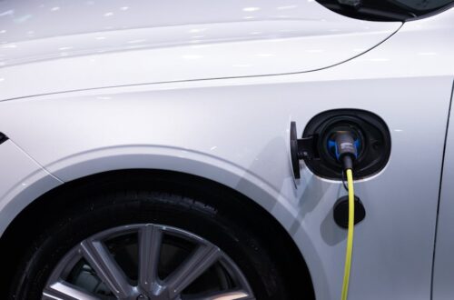 Een laadstation voor elektrische voertuigen in een bedrijfsomgeving met meerdere elektrische auto’s.