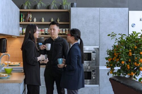 Een moderne kantoor pantry met koelapparatuur, koffiezetapparaat en snacks, die bijdraagt aan een efficiënte werkomgeving.