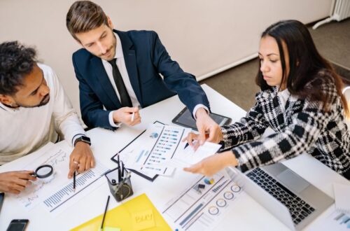 Een HR-specialist die strategieƫn bespreekt voor het verminderen van WGA-kosten met een team van werkgevers en uitzendbureaus.