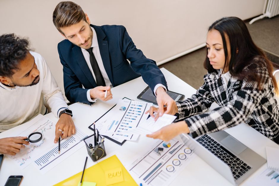 Een HR-specialist die strategieën bespreekt voor het verminderen van WGA-kosten met een team van werkgevers en uitzendbureaus.