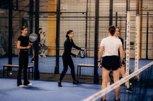 Een speler die een padelracket vasthoudt op de baan, klaar voor actie met een focus op kracht en controle.