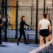 Een speler die een padelracket vasthoudt op de baan, klaar voor actie met een focus op kracht en controle.