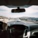 Een dashboardcamera met accessoires zoals een houder en oplader in een auto, die gebruikers helpt bij veilig rijden.