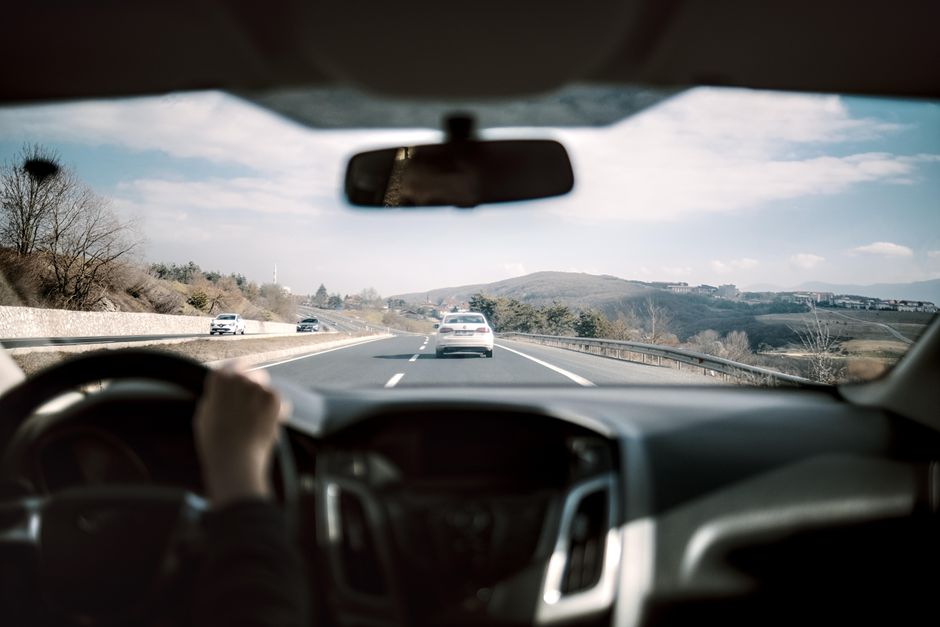 Een dashboardcamera met accessoires zoals een houder en oplader in een auto, die gebruikers helpt bij veilig rijden.